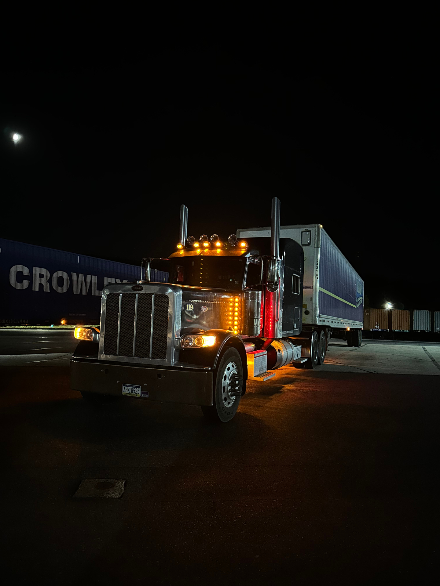 Red semi-truck on highway at dusk